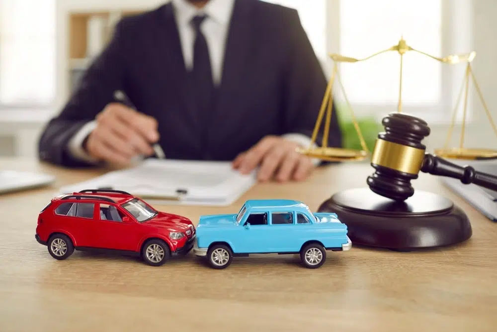 Car accident lawyer sitting by his desk signing documents for a car accident personal injury case